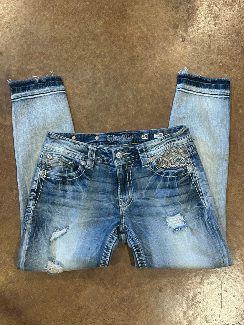 Miss Me Signature Distressed Ankle Skinny Jeans with Embellished Pockets.